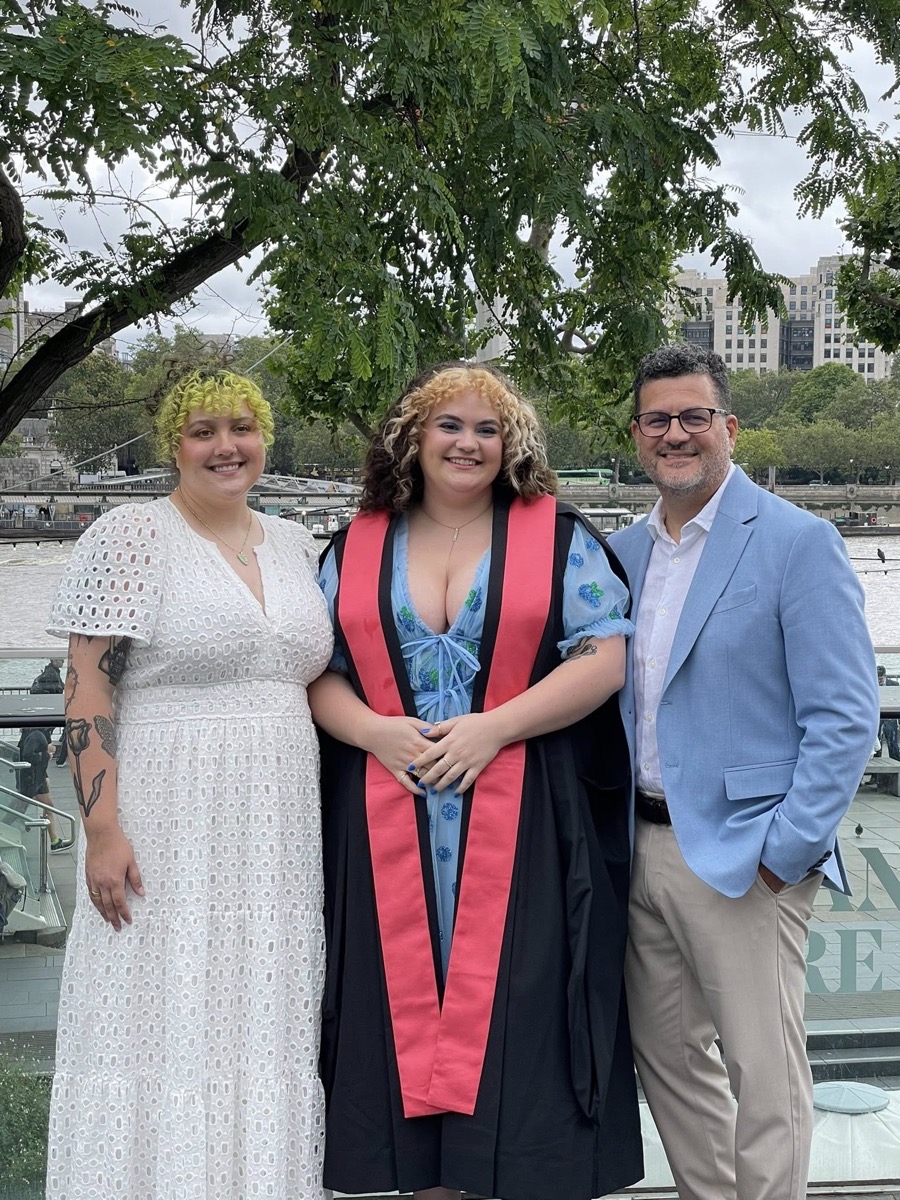 Javier with his daughters at a graduation